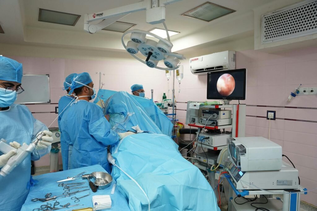 Healthcare professionals in operating room conducting laparoscopic surgery with advanced medical equipment.