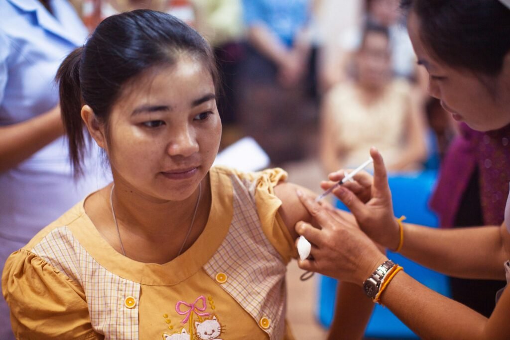 Healthcare scene with a nurse giving an injection to a patient indoors.