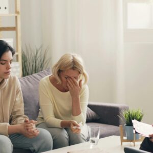 Emotional family therapy session with a therapist indoors, conveying connection and support.