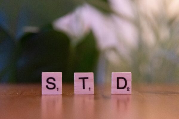 Scrabble tiles spelling 'STD' symbolize sexually transmitted diseases awareness and prevention.