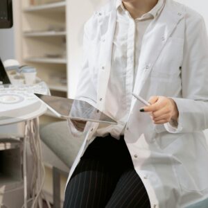 Doctor holding a tablet in a modern medical office during a patient consultation.