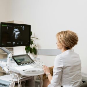 A healthcare professional conducting an ultrasound scan in a clinic setting.