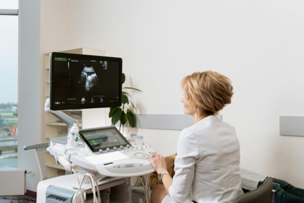 A healthcare professional conducting an ultrasound scan in a clinic setting.