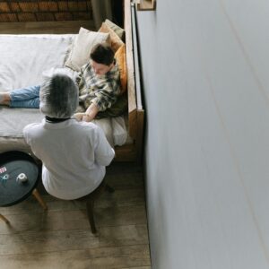 A doctor tends to a young patient in a cozy bedroom environment.