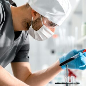 A researcher in a lab coat carefully examines a test tube, symbolizing scientific discovery and research.